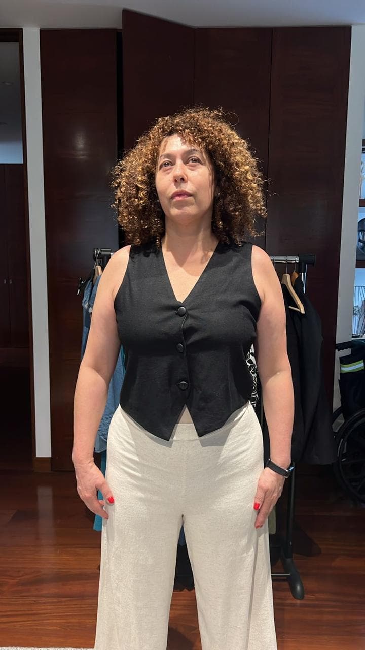 Clienta Gregharia con chaleco negro y pantalón crema